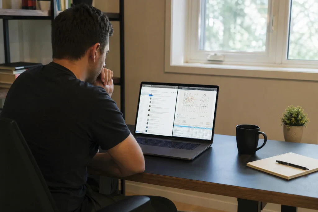 Person sitter vid ett skrivbord och jämför två webbläsarfönster på en laptop, mitt i researchen kring Kinesiska jättar kas...