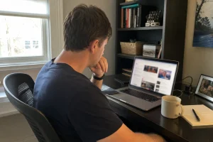En person sitter vid sitt skrivbord och läser om lag och ordning viktigaste frågan för väljarna på sin laptop.