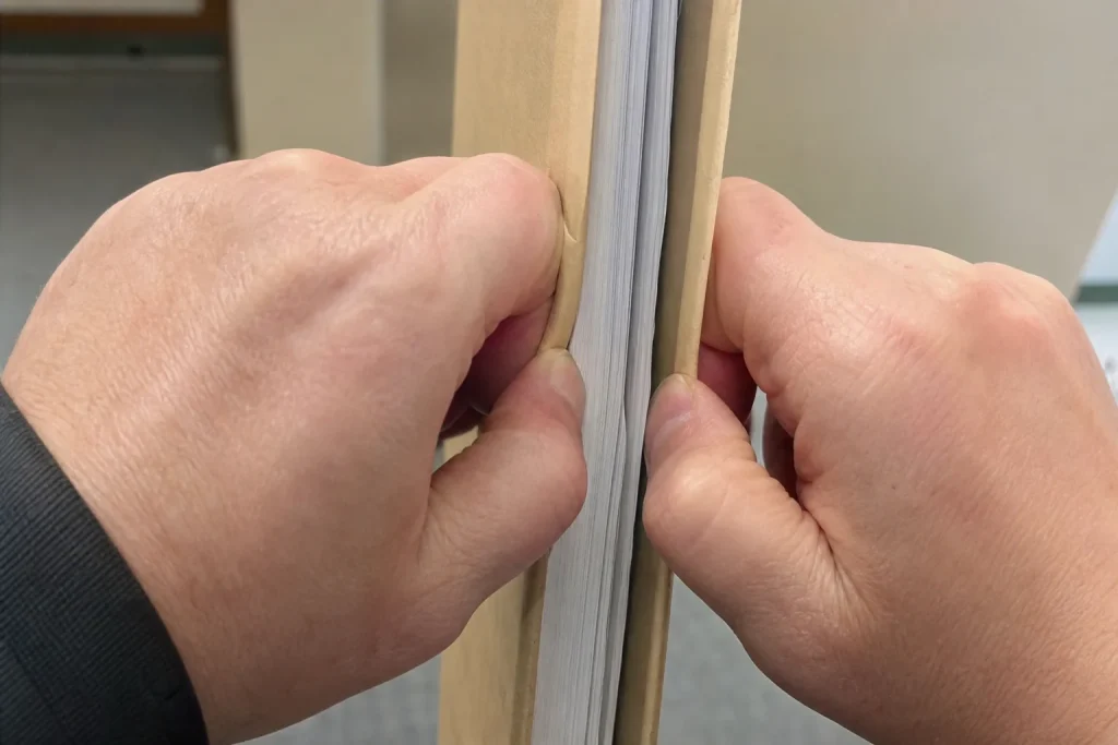 Händer håller hårt i en tjock pärm i samband med Feds räntebesked: