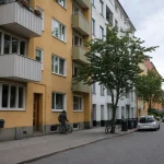 En svensk bostadsgata en overcast dag med lägenhetshus och cyklar, relevant för boendekostnader 2027.