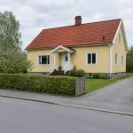 Gul villa med rött tegeltak, ett hus där lagfart kostnad blir aktuell vid köp